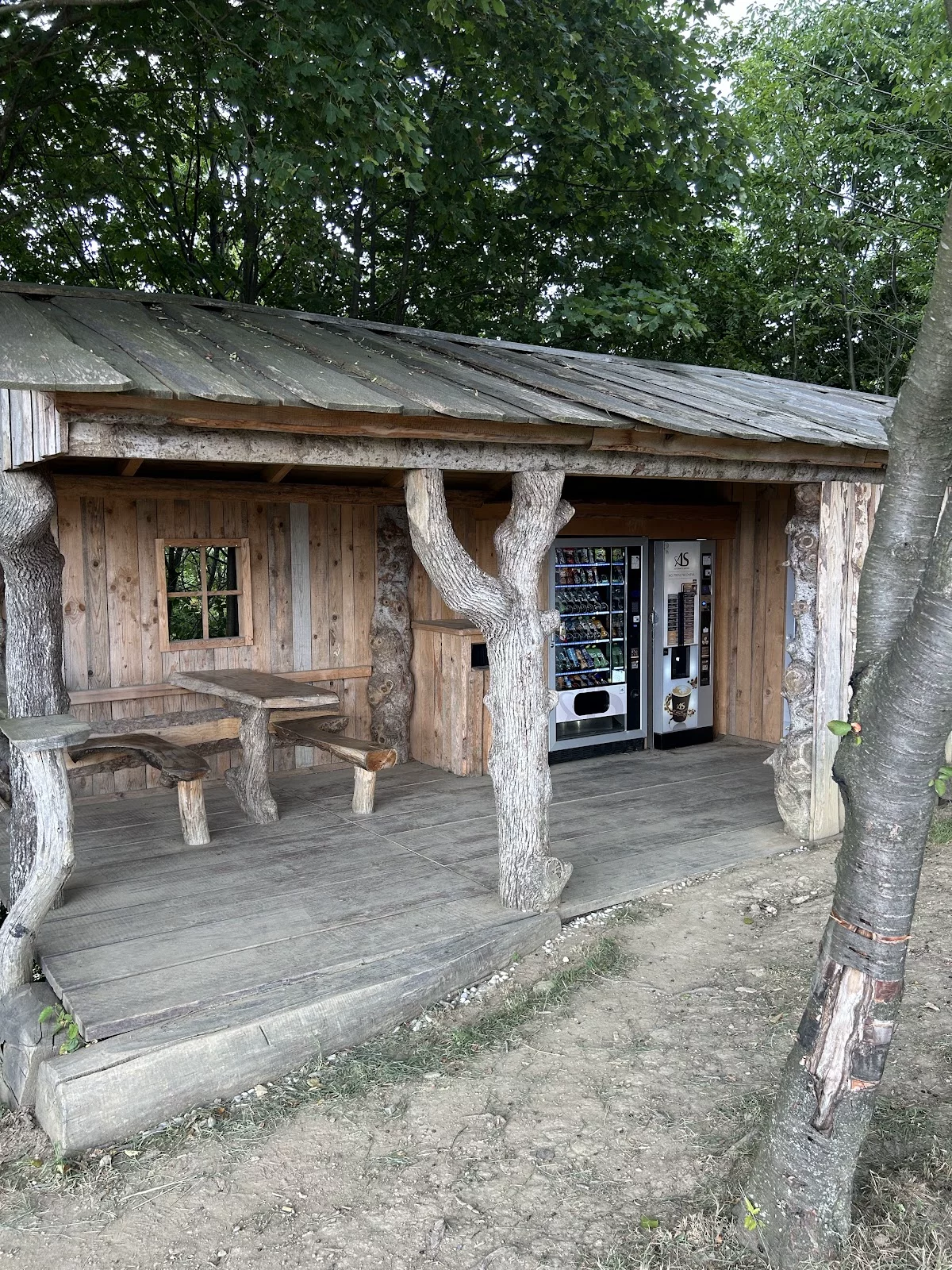 Kalvarijska uta z leseno mizo in klopmi pod nadstreškom.